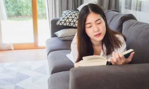 自宅で読書をしている若い女性